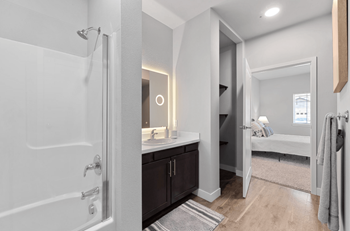 A bathroom with a shower and a sink and a mirror